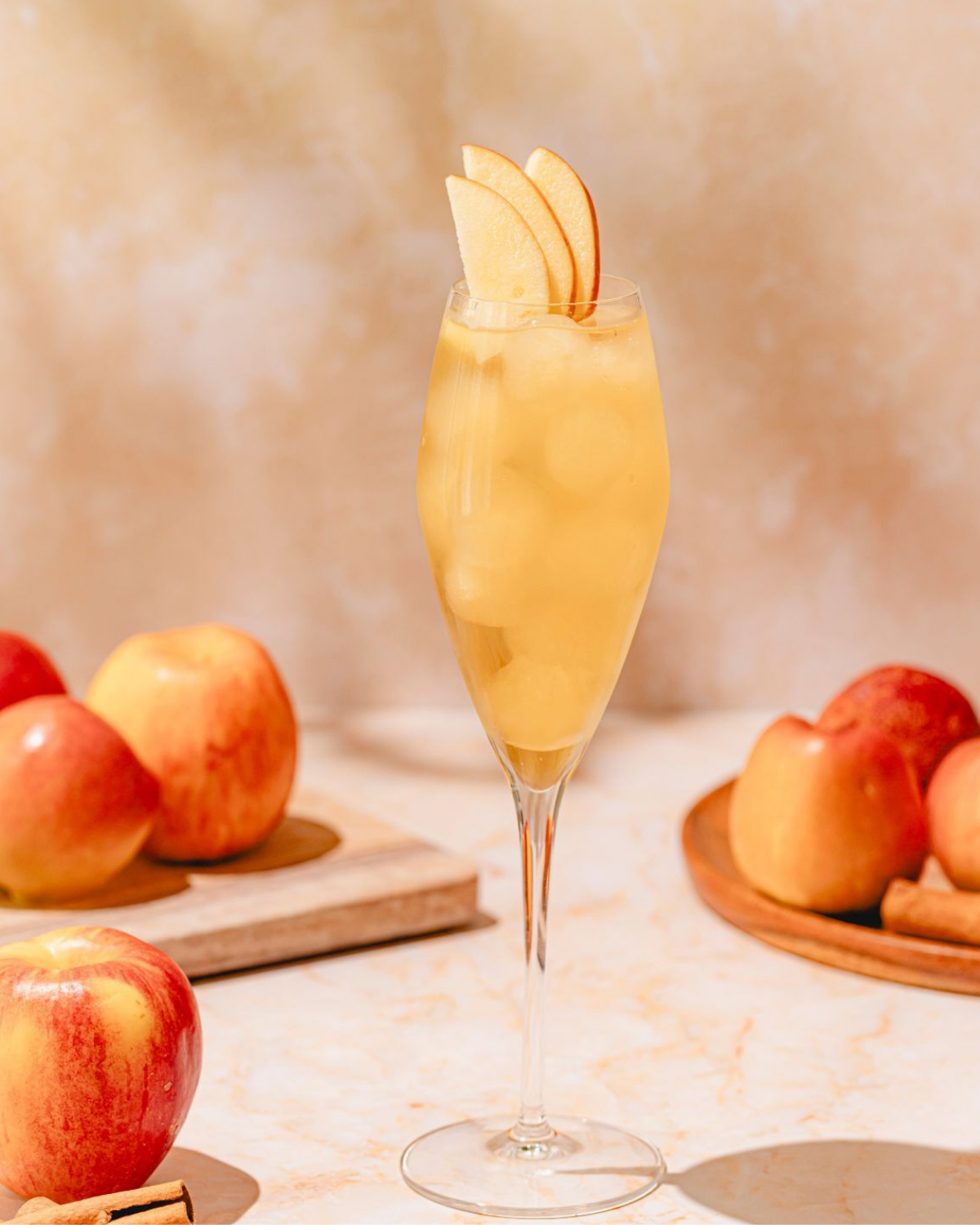 A class of Fall Cocktail with apples around it