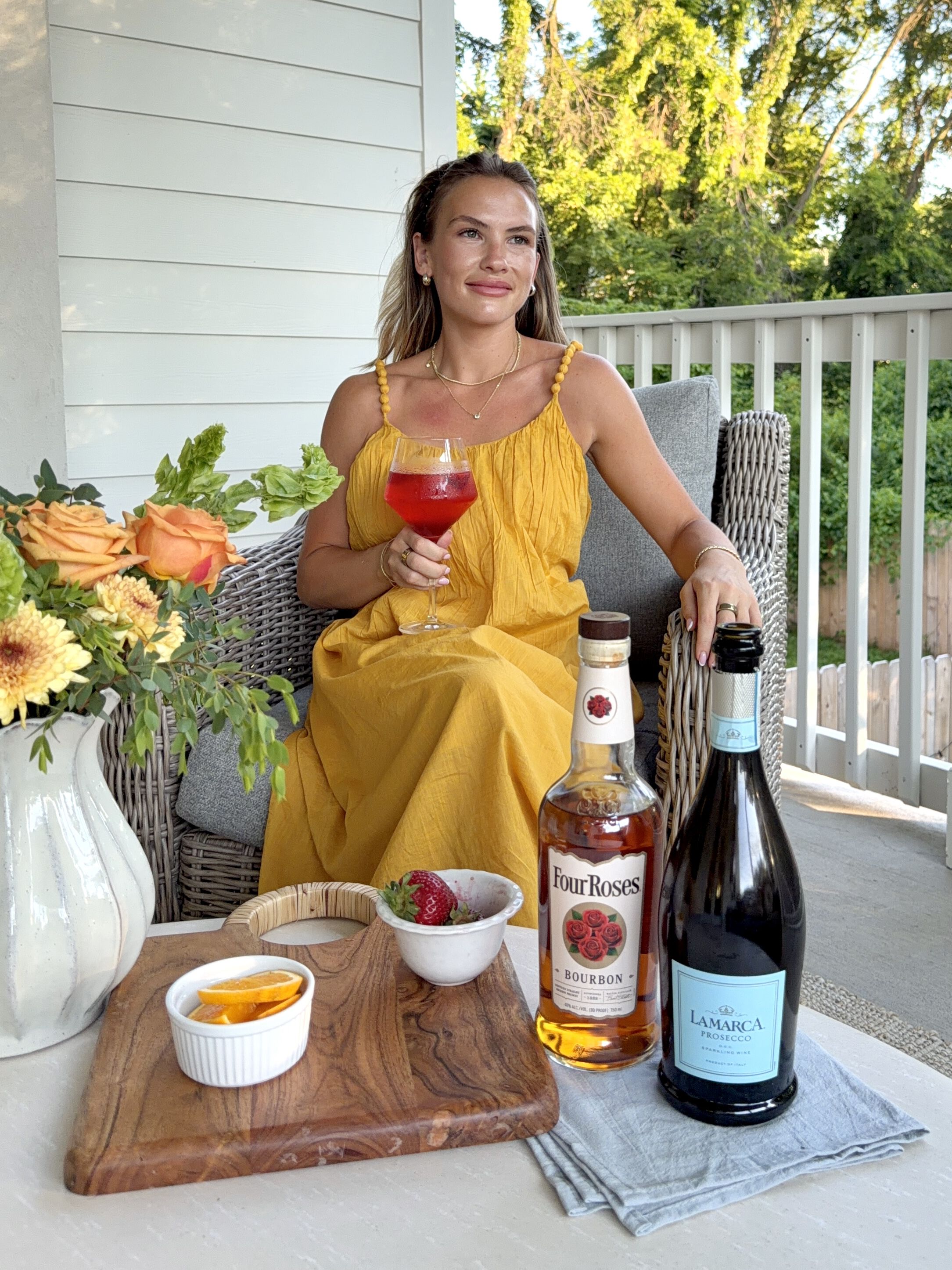 Influencer image with four roses bottle and la marca bottle drinking her sunset spritz